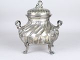 an antique silver plated teapot with a lid on a stand