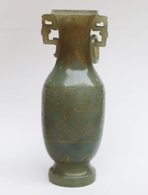un vase vert posé sur une surface blanche