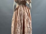 a woman ' s dress on display in a museum display case