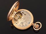 an antique pocket watch with a gold case on a black surface