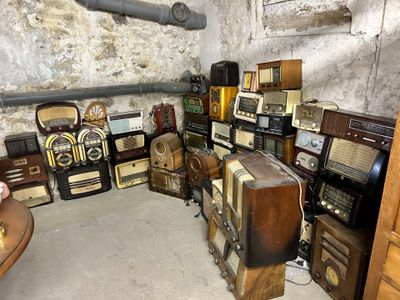 a lot of old radio ' s and other items in this room