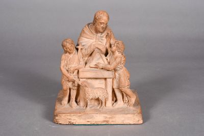 an old statue of a man sitting on top of a table surrounded by children