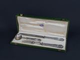 a silverware set in a green case on a black background