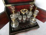 bottles and glasses in a wooden box on a white surface