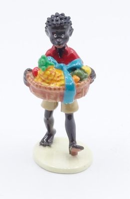 a figurine of a boy holding a basket of fruit
