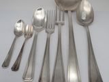 a lot of silver spoons and spoons sitting on a table