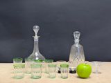 bottles and glasses on a table with a green apple in front of them