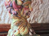 a ceramic figurine of a woman with fruits and vegetables on her head