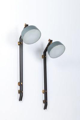 deux appliques noires et dorées sur un mur blanc