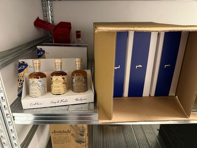 plusieurs bouteilles d'alcool dans une boîte posée sur une étagère