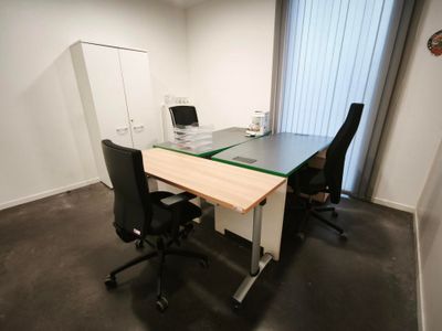un bureau avec deux chaises et un ordinateur dessus