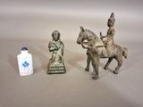 trois figurines représentant des personnes à cheval et un vase