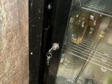 a glass door that has a bunch of bottles inside of it