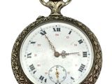 a silver pocket watch with roman numerals on it
