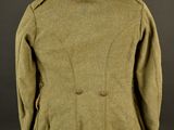 a green jacket on a mannequin stand against a black background