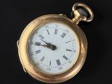 une montre de poche en or avec des chiffres romains