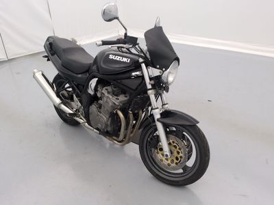a black motorcycle parked in a room with a white wall