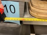 a person measuring a piece of wood with a tape
