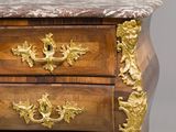 a marble top chest of drawers with gold accents