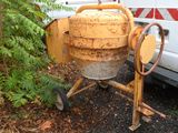 a cement mixer sitting on the ground next to a truck