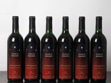 six bouteilles de vin sont alignées sur une table en bois