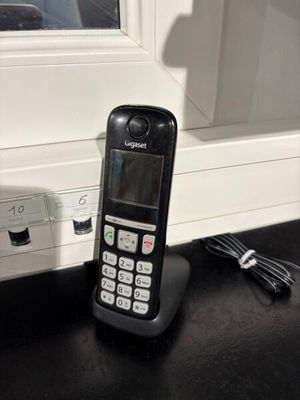 un téléphone portable posé sur une table près d'une fenêtre