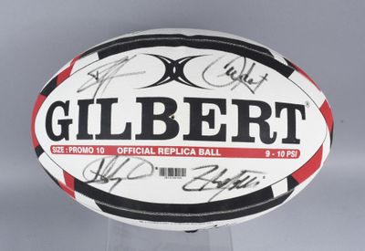 an image of a signed gilbert rugby ball on a clear base
