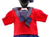 une poupée vêtue d'une robe rouge et bleue et d'un chapeau