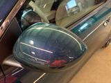 a reflection of a car ' s side mirror on the side of a car