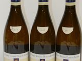 trois bouteilles de vin posées sur une table, l'une à côté de l'autre