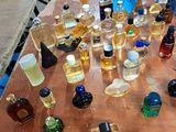 many bottles of perfume sitting on a wooden table