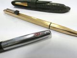 a pen and a ballpoint pen sitting on a table