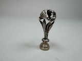 a silver vase with a flower on it on a table