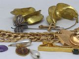 a lot of gold jewelry on a white surface