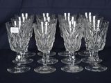 six verres en cristal sont alignés sur une surface noire