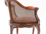an image of a wooden chair with an orange cushion on it