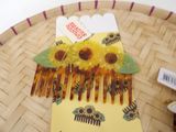 a yellow comb with sunflowers on it sitting on a table