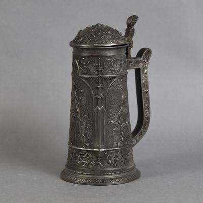 an antique pewed beer mug with a handle on a gray background