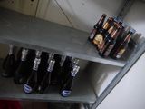 many bottles of beer sitting on a shelf in a room