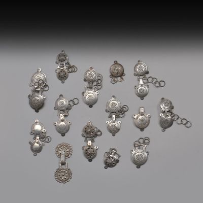 un assortiment de breloques et de pendentifs en métal argenté sur un fond gris