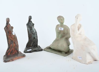 trois figurines représentant une femme et un homme assis sur une surface blanche
