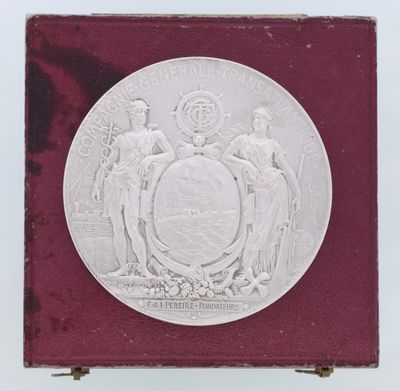 un gros plan d'une médaille d'argent posée sur un socle, sur fond blanc