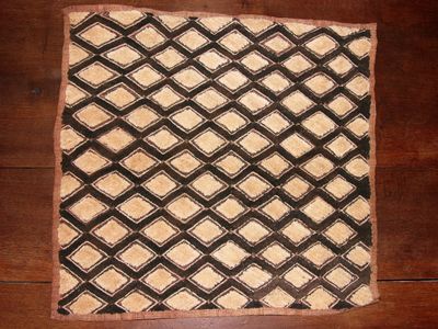 une photo d'un tapis noir et blanc posé sur un parquet