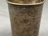 a silver cup with a picture of a bird on it