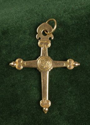 an image of a gold cross on a green velvet surface