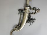 une vieille dague ornée d'un serpent, accrochée au mur