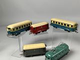 four toy trains sitting on display on a clear stand