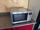 a silver microwave sitting on top of a red cabinet