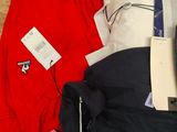 a pile of clothing on the floor next to a laptop