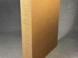 a brown book sitting on top of a table next to a gray wall